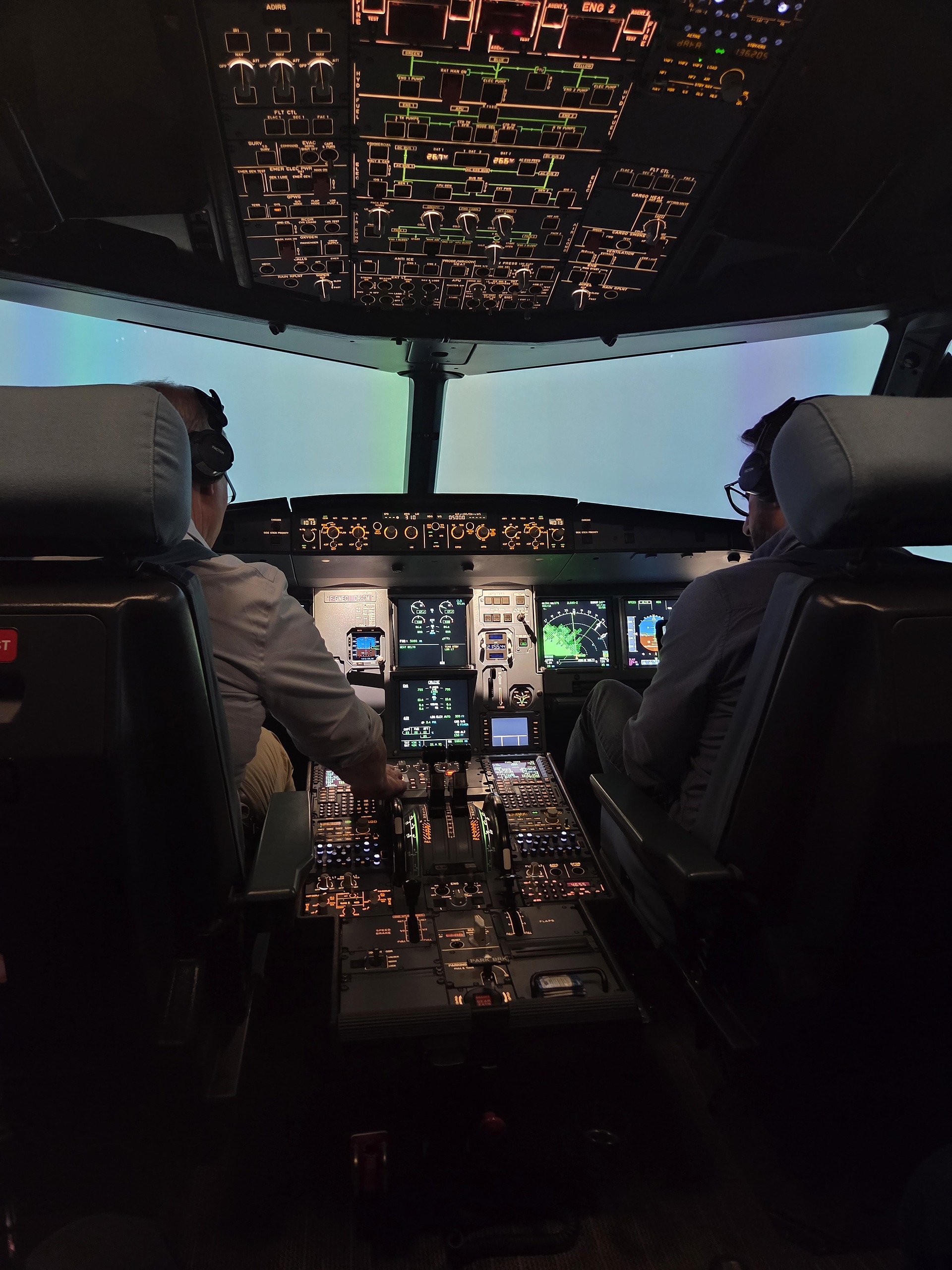 Two pilots in the cockpit during a simulator session at dusk